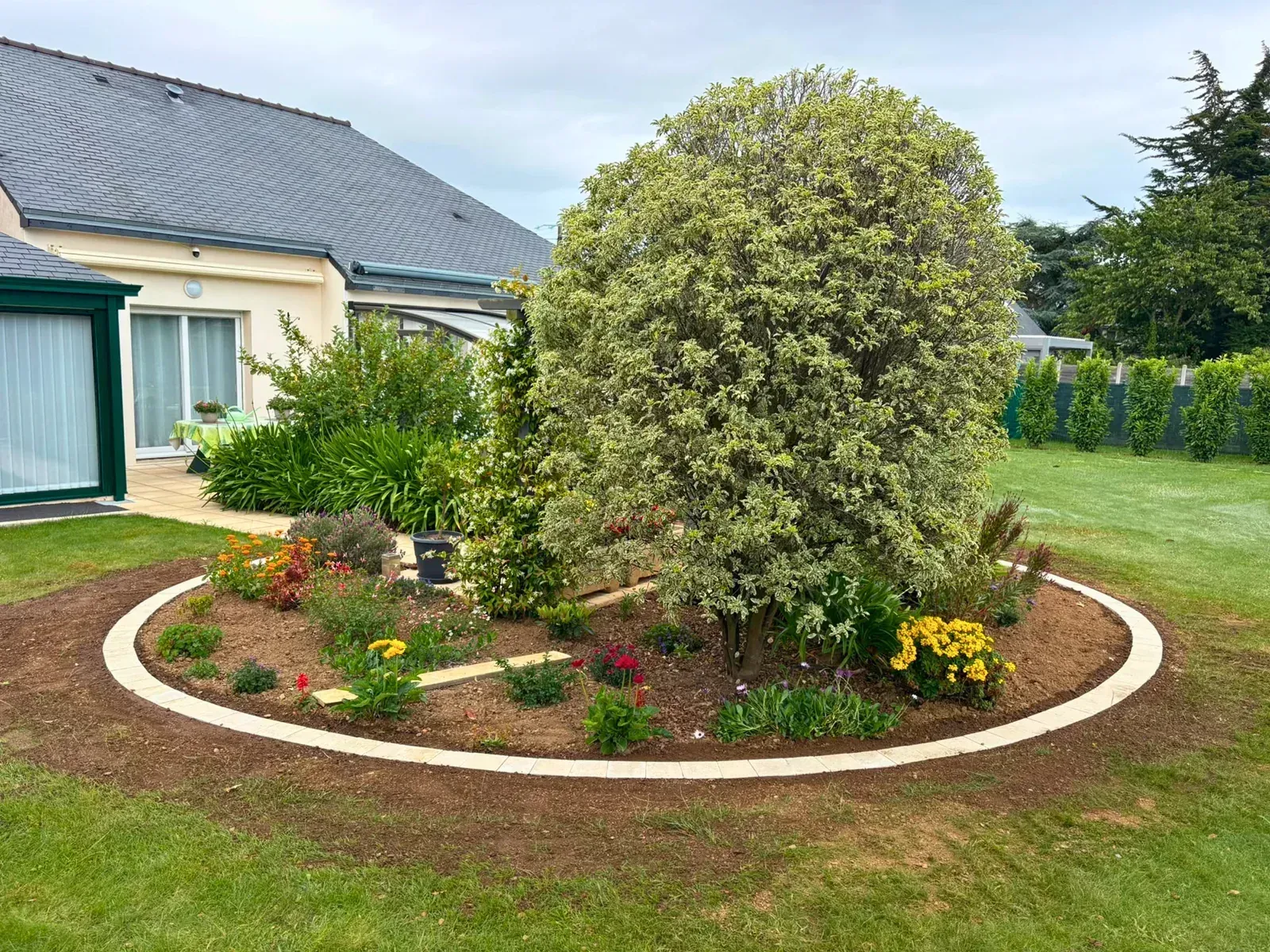 Massif fleuri et bordure pavée réalisés par Robot'Vert